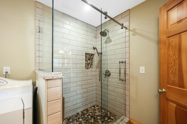 bathroom featuring washer / dryer and a shower stall