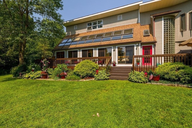 rear view of property with a deck and a lawn