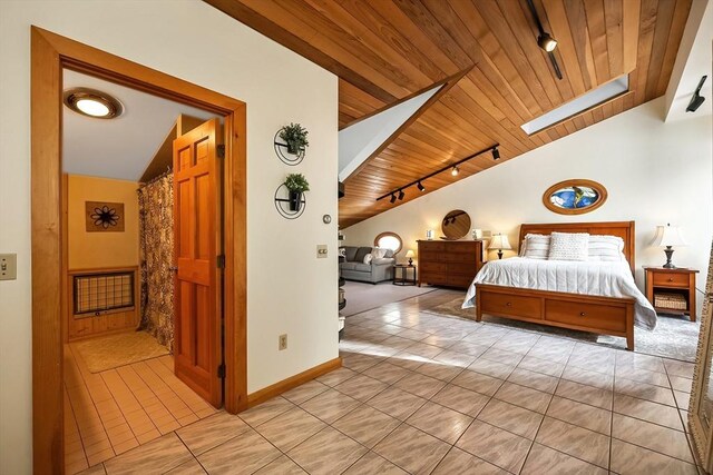 bedroom featuring light tile patterned flooring, wood ceiling, baseboards, lofted ceiling with skylight, and track lighting