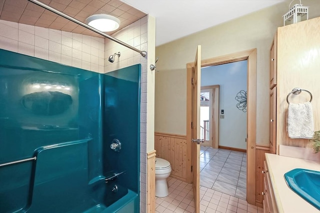 full bathroom with bathtub / shower combination, toilet, wainscoting, vanity, and tile patterned floors