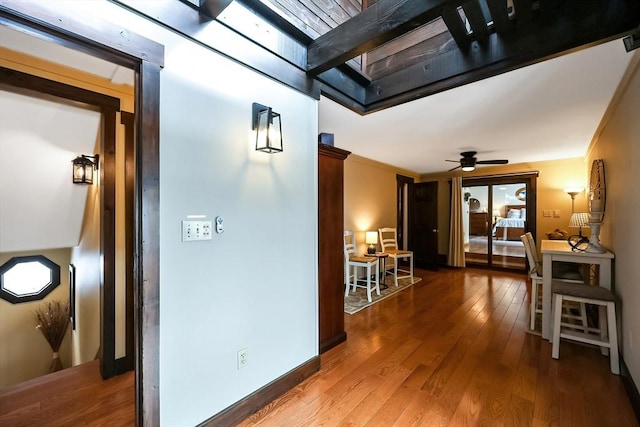 hallway featuring hardwood / wood-style flooring and baseboards