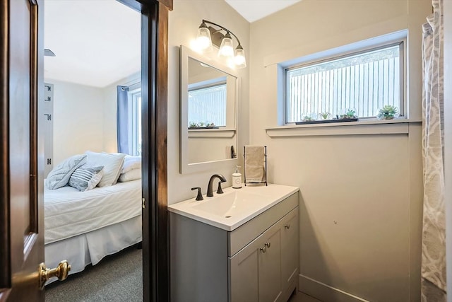 ensuite bathroom with connected bathroom and vanity