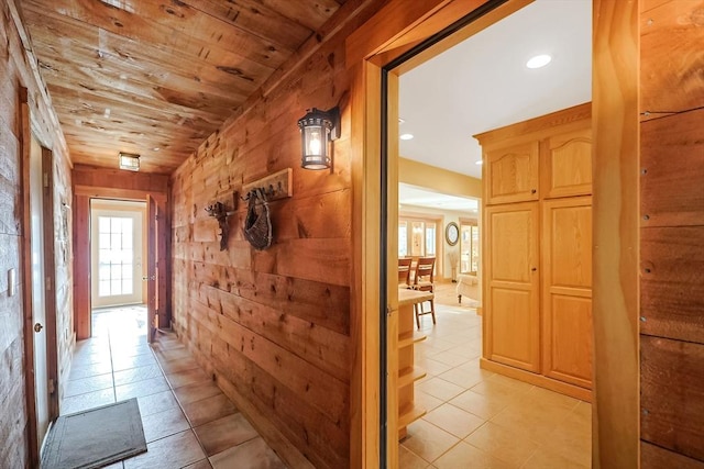 hall featuring recessed lighting, wood ceiling, light tile patterned flooring, and wood walls