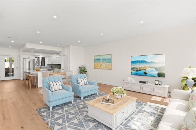 living area featuring light wood-type flooring, recessed lighting, baseboards, and baseboard heating