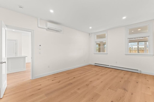 empty room featuring a baseboard heating unit, light wood-style flooring, a wall mounted air conditioner, recessed lighting, and baseboards