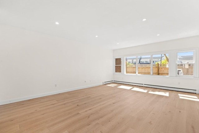 unfurnished room with a baseboard radiator, light wood-style floors, baseboards, and recessed lighting
