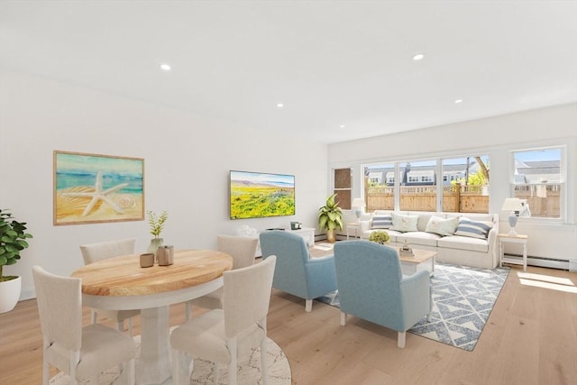 dining room featuring light wood-style floors, baseboard heating, and recessed lighting