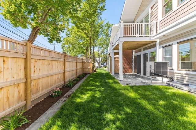 view of yard with a balcony, a patio area, and central AC