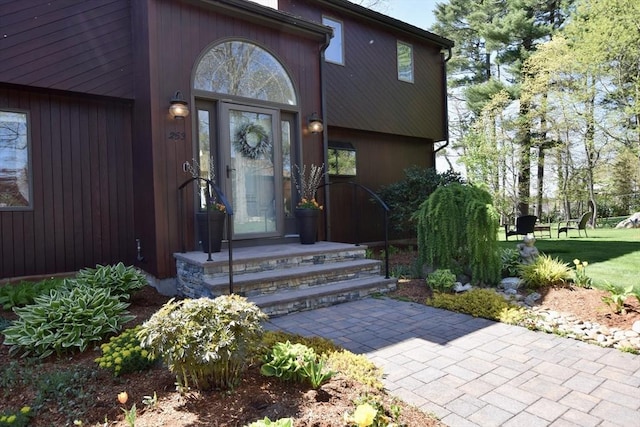 doorway to property with a lawn