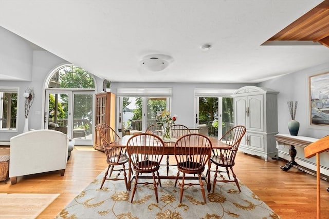 dining area with a baseboard heating unit and light wood-style flooring