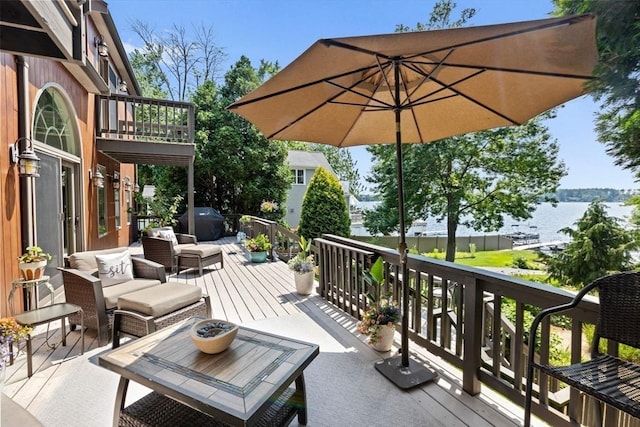 deck featuring a water view and outdoor lounge area