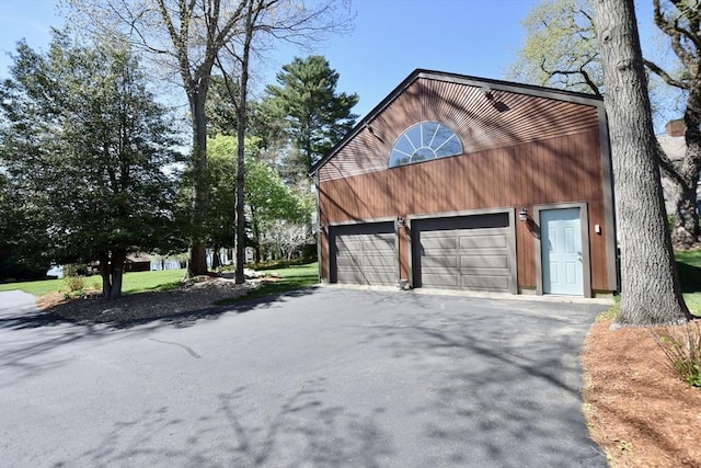 view of side of home with a garage and driveway