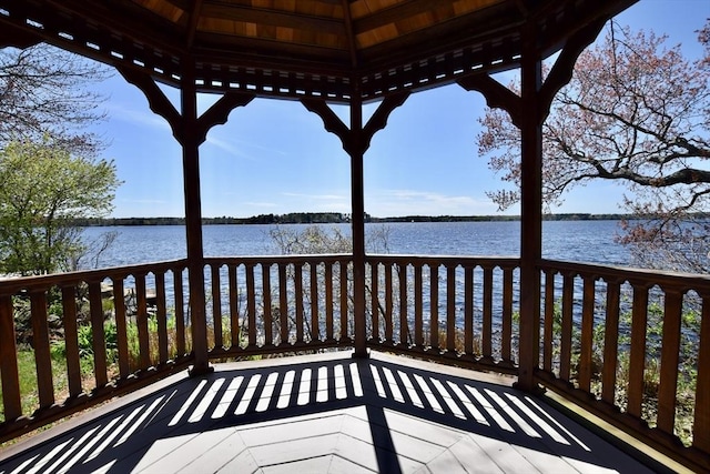wooden deck with a water view and a gazebo