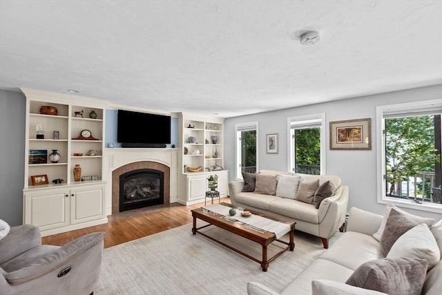 living area with wood finished floors and a tile fireplace