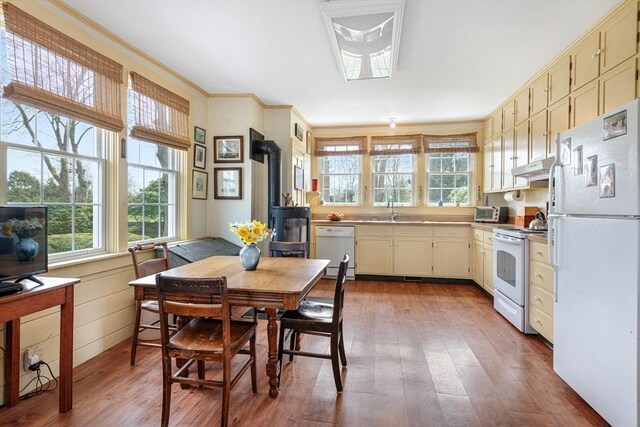 167 Bakerville, Dartmouth, MA 02748 - kitchen featuring white appliances, a wood stove, under cabinet range hood, healthy amount of natural light, and crown molding