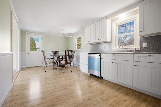 kitchen featuring a wealth of natural light, stainless steel dishwasher, white cabinets, and light wood-type flooring