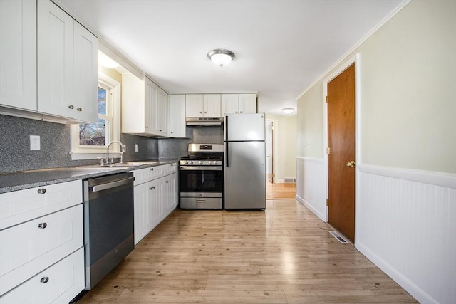 kitchen featuring white cabinetry, sink, light wood-type flooring, and appliances with stainless steel finishes