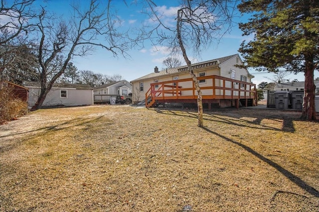 rear view of house featuring a deck and a lawn