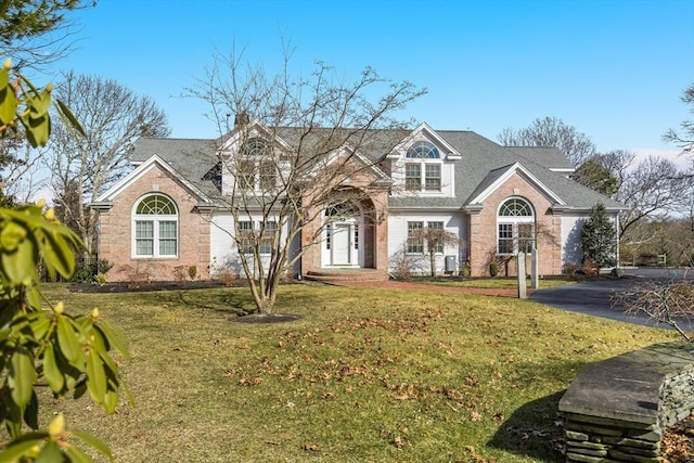 view of front of property featuring a front lawn and brick siding