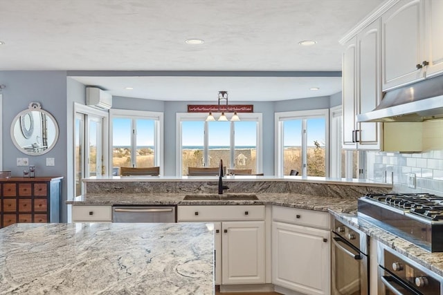 kitchen featuring gas cooktop, a wall mounted AC, a sink, under cabinet range hood, and stainless steel dishwasher