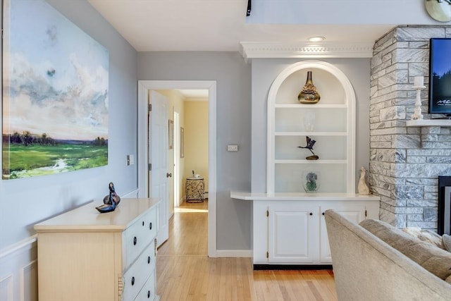 hall with built in features, baseboards, and light wood-type flooring