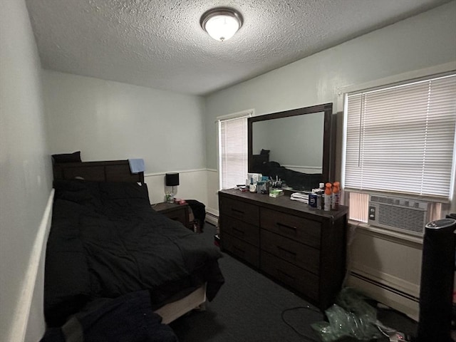 bedroom featuring cooling unit, a textured ceiling, and a baseboard heating unit