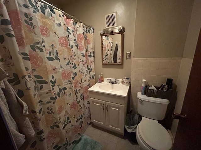 bathroom with tile patterned floors, vanity, toilet, and walk in shower