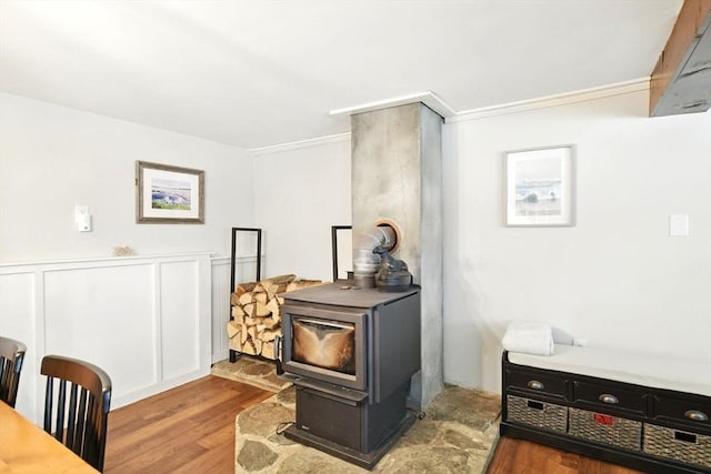 interior space featuring crown molding, a wood stove, and wood finished floors