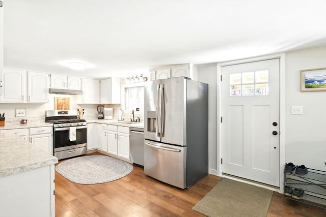 kitchen featuring a sink, white cabinetry, appliances with stainless steel finishes, and wood finished floors