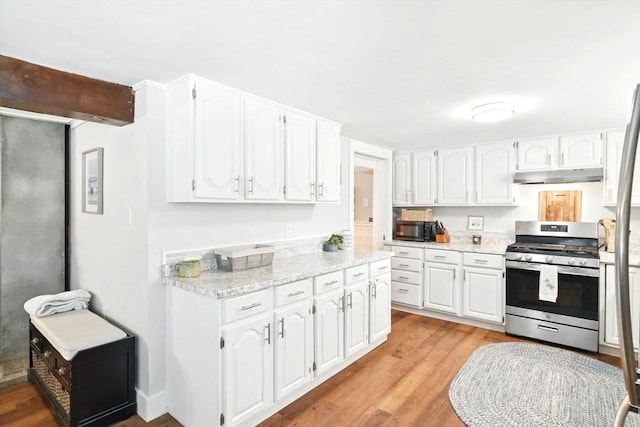 kitchen featuring stainless steel range with gas stovetop, white cabinets, under cabinet range hood, and black microwave