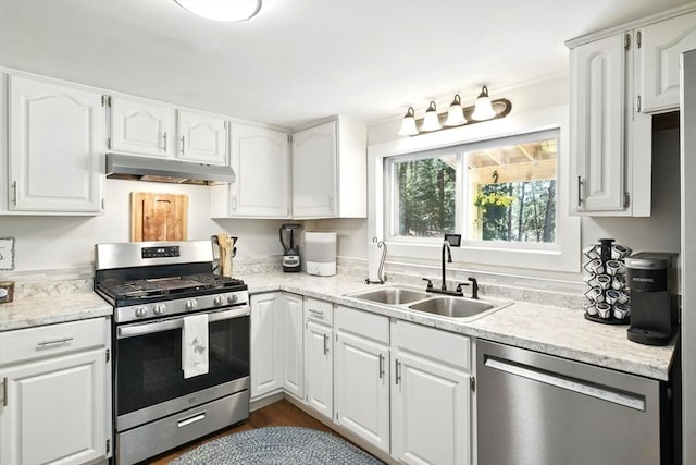 kitchen featuring a sink, light countertops, stainless steel appliances, white cabinetry, and under cabinet range hood