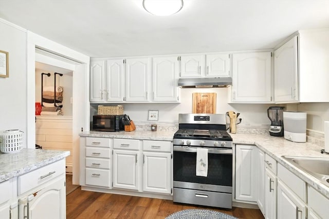 kitchen featuring black microwave, white cabinets, under cabinet range hood, and gas stove