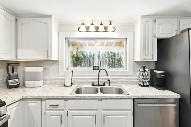 kitchen with a sink, light countertops, stainless steel appliances, and white cabinetry