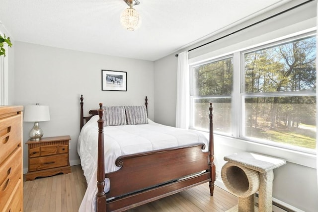 bedroom with baseboard heating and light wood-style flooring