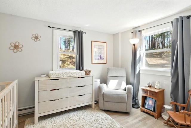 sitting room with a baseboard radiator and light wood-style flooring