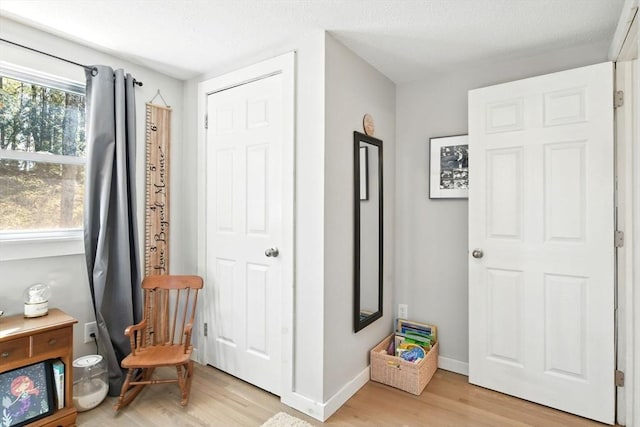 sitting room featuring baseboards and light wood finished floors