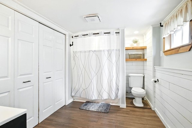 bathroom featuring a closet, toilet, wood finished floors, and visible vents