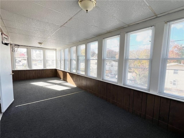 unfurnished sunroom featuring a paneled ceiling and a wealth of natural light