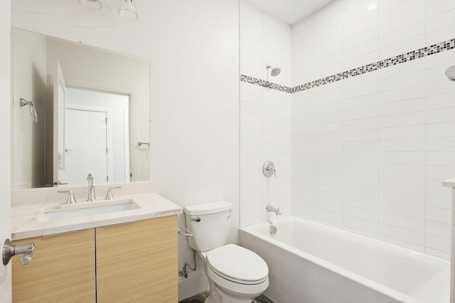 full bathroom featuring vanity, tiled shower / bath combo, and toilet