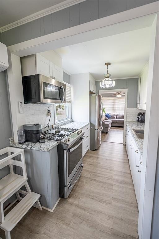 1001 Belleville Ave, New Bedford, MA 02745 - kitchen featuring appliances with stainless steel finishes, decorative backsplash, light wood-style flooring, ornamental molding, and white cabinets