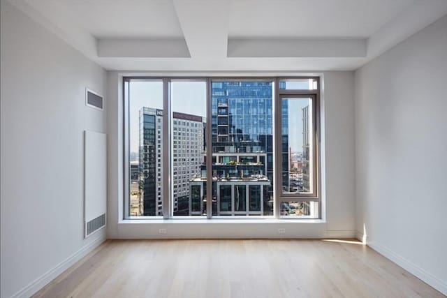 133 Seaport Blvd Unit 1007, Boston, MA 02210 - unfurnished room featuring wood finished floors, plenty of natural light, a view of city, baseboards, and floor to ceiling windows