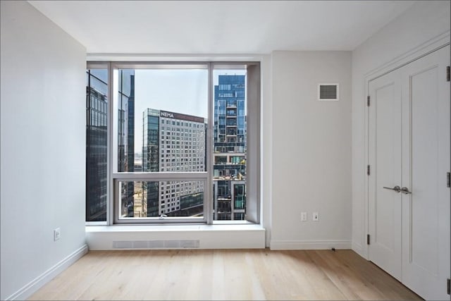 133 Seaport Blvd Unit 1007, Boston, MA 02210 - unfurnished room with wood finished floors, floor to ceiling windows, baseboards, and a city view