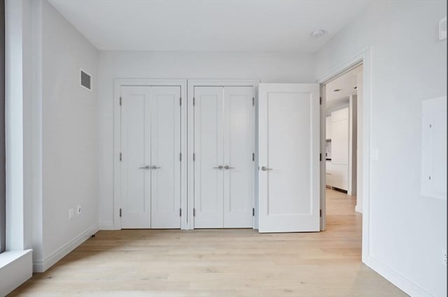 133 Seaport Blvd Unit 1007, Boston, MA 02210 - unfurnished bedroom with light wood-type flooring, two closets, and baseboards