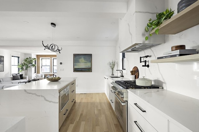 kitchen featuring pendant lighting, white cabinets, high end range, a center island, and wall chimney exhaust hood