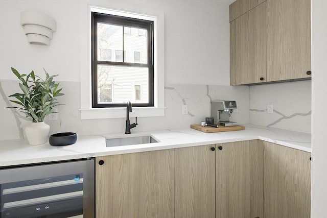 kitchen featuring sink, wine cooler, decorative backsplash, light stone countertops, and light brown cabinets