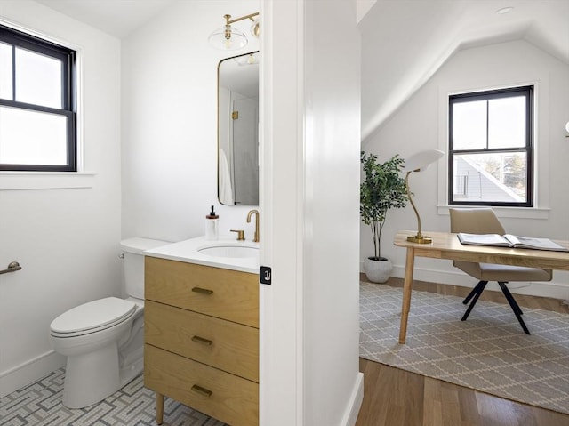 bathroom with vanity, a wealth of natural light, toilet, and vaulted ceiling