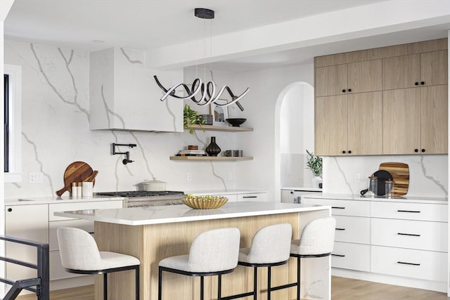 kitchen featuring decorative backsplash, a breakfast bar, and a kitchen island