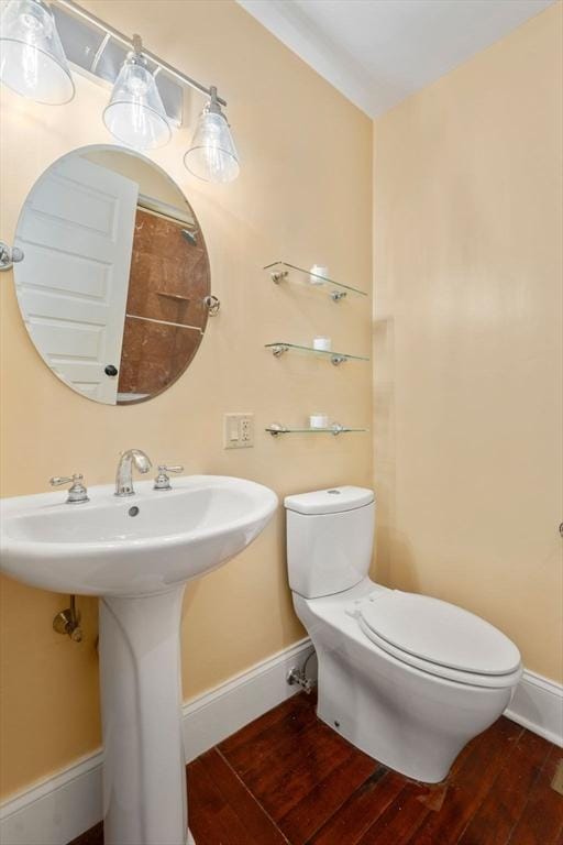 bathroom with hardwood / wood-style floors, sink, and toilet