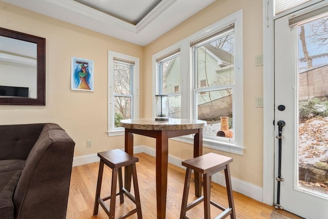 interior space featuring light hardwood / wood-style flooring, ornamental molding, and a raised ceiling