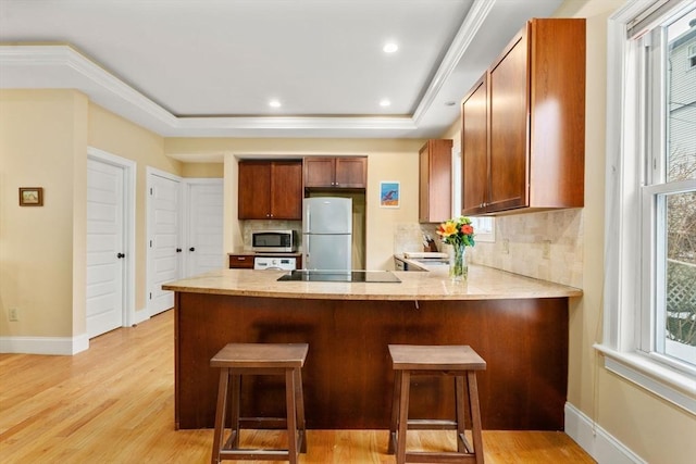 kitchen featuring fridge, a kitchen breakfast bar, and kitchen peninsula